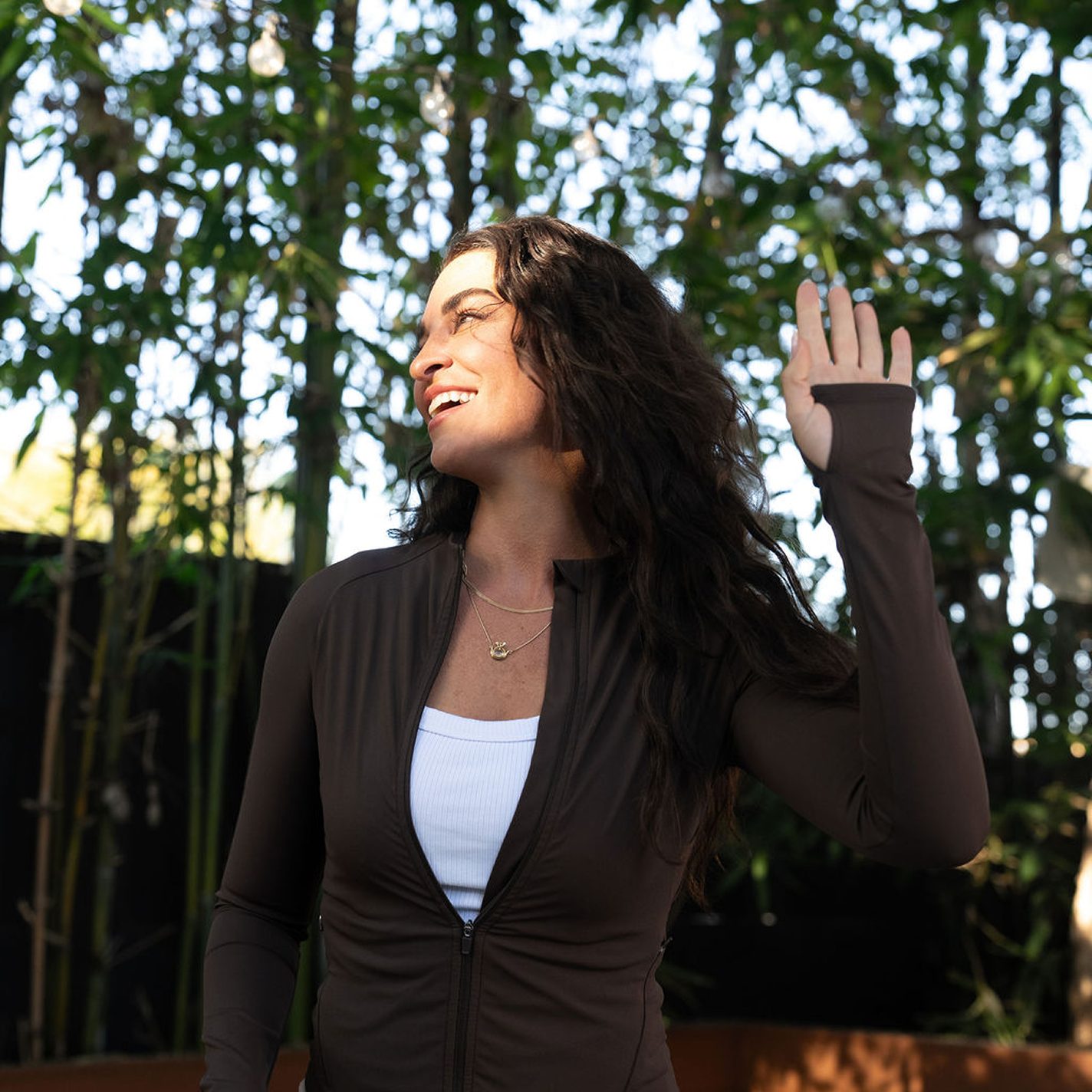 Woman in athletic wear standing in front of bamboo trees